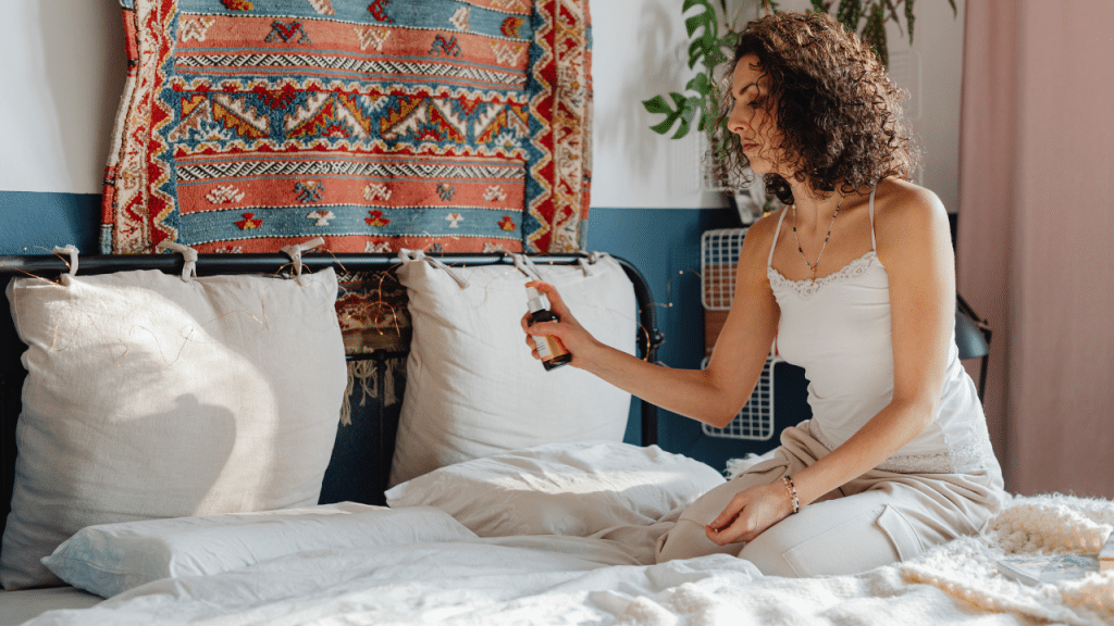 a girl spraying sleep scent on the pillow